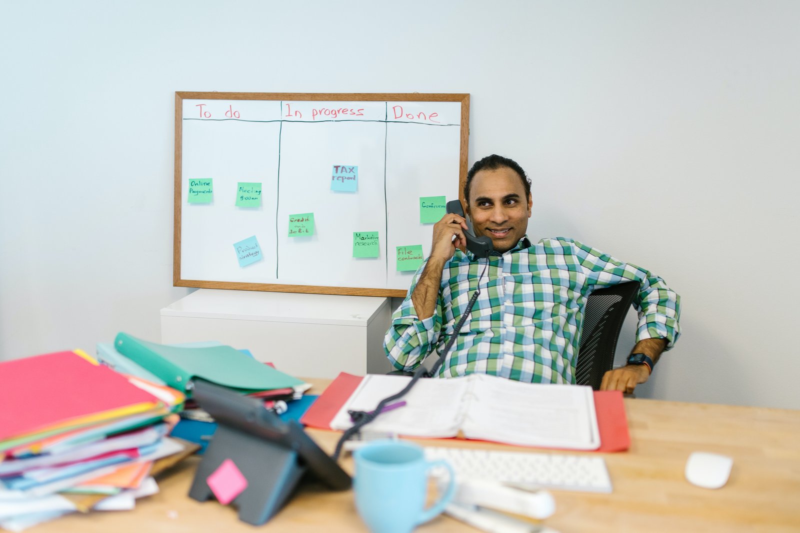 Airtel India Business Customer speaking with customer care on landline phone, seated at desk.