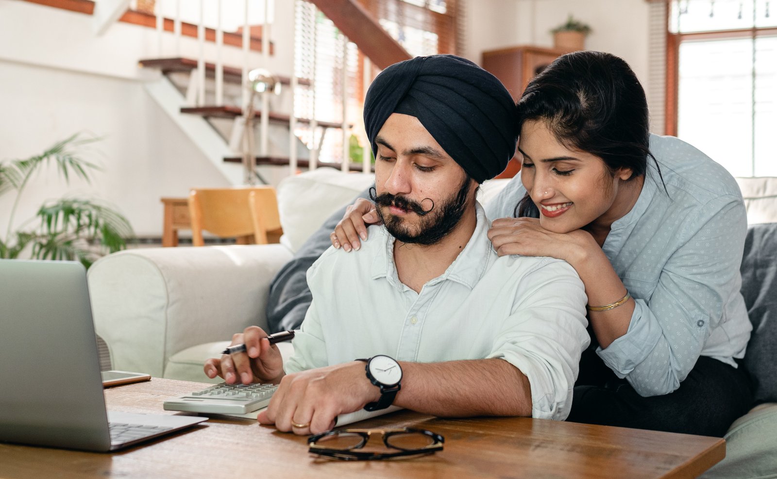 Husband calculating on a calculator with wife observing