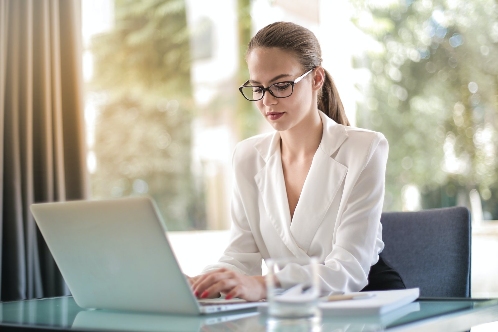 A Kotak Mahindra Customer Care representative typing on a laptop