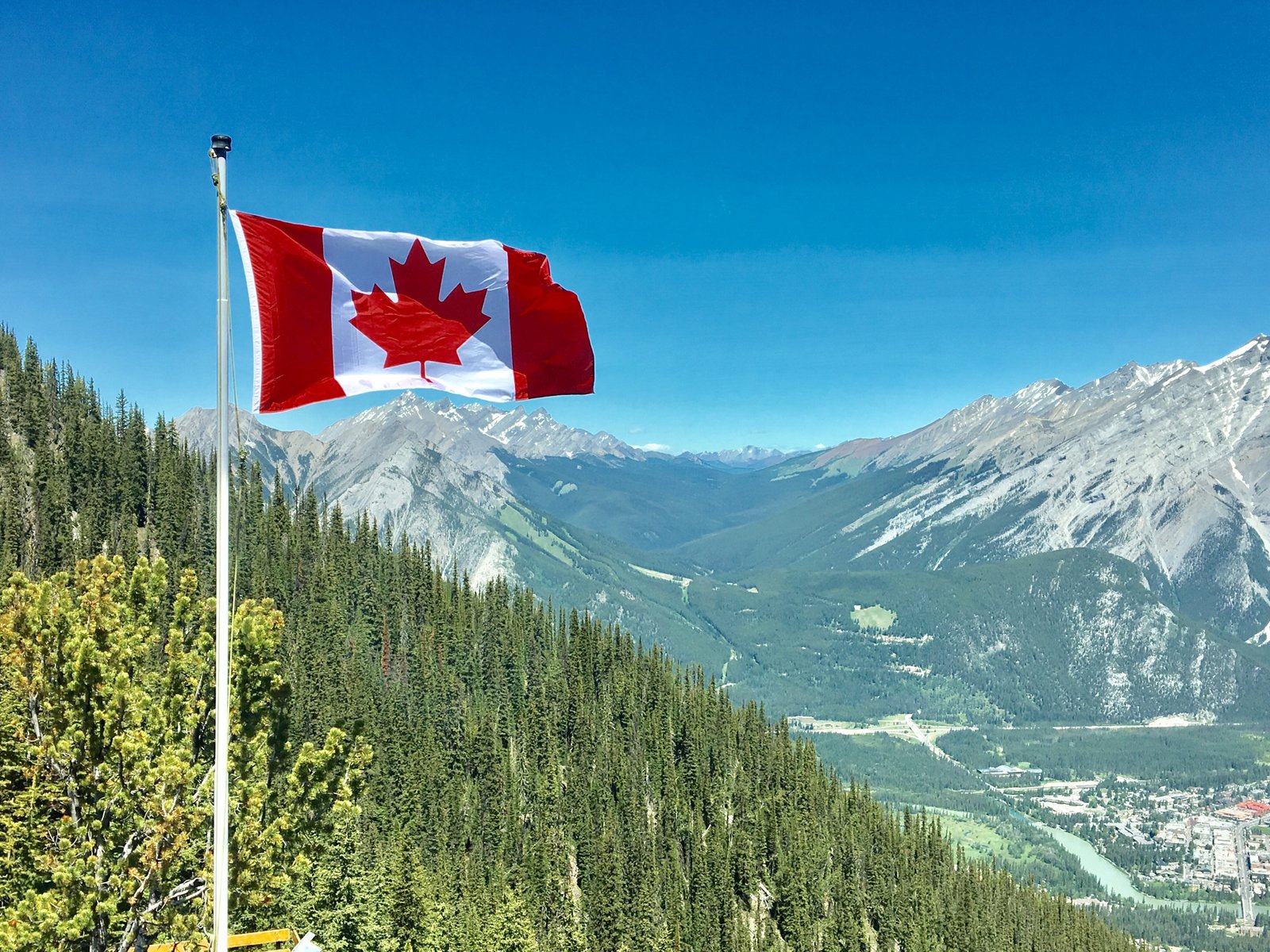 Scenic Canadian mountain landscape with visible Canadian flag.