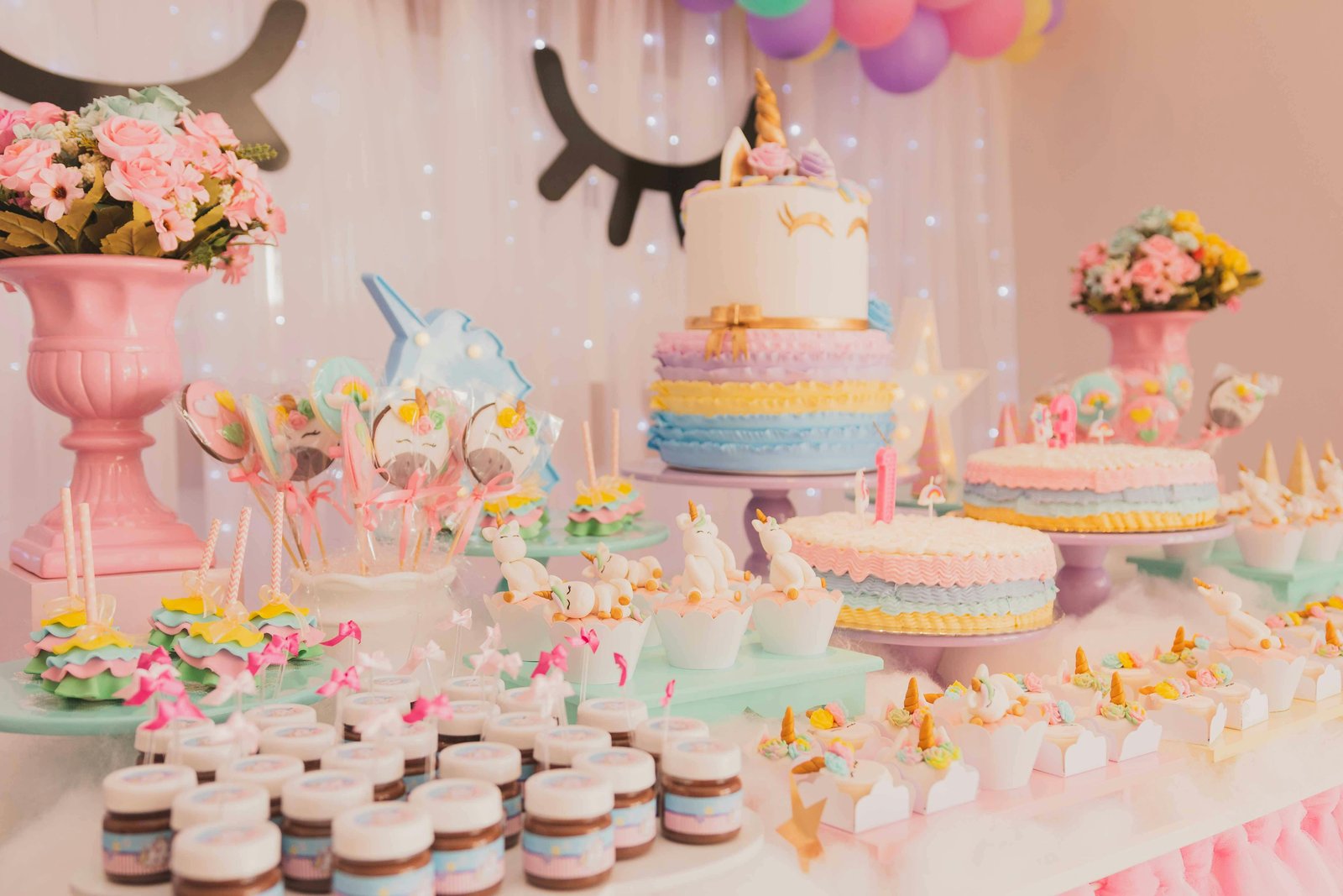 A table with cakes, desserts on it indicating a birthday party celebration