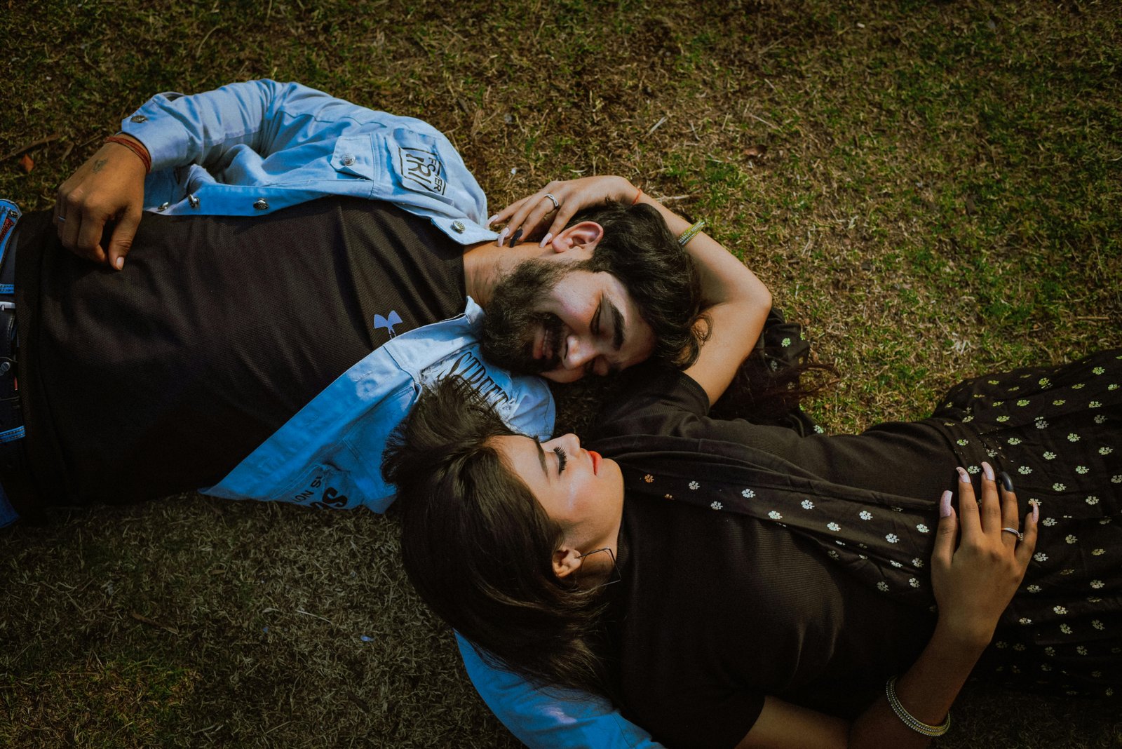 An Indian couple lying on the ground looking adorably at each other