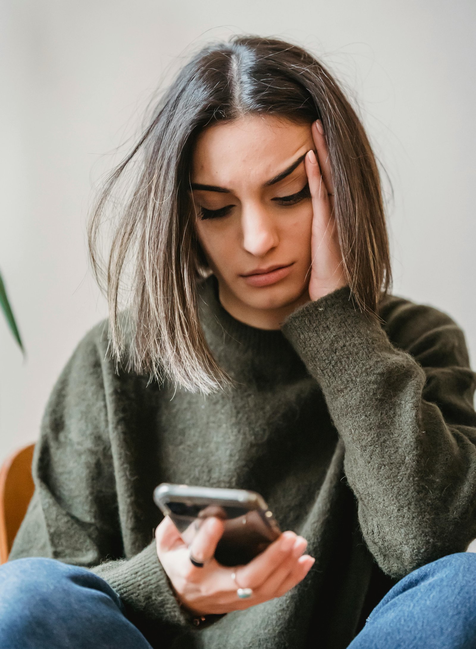 An Indian girl looking at her mobile phone with a worried look